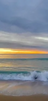 Serene beach with ocean waves at sunrise under a colorful sky.