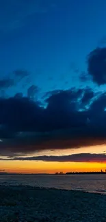 Beach sunset wallpaper with dark blue sky and warm orange horizon.