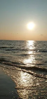 Serene beach sunset with shimmering ocean waves.