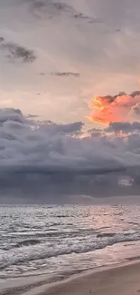 A serene beach at sunset with clouds and ocean waves.