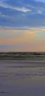 Serene beach sunset with pastel sky hues and calm ocean waves.