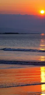 Vibrant beach sunset with orange hues and gentle waves.