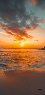 Tranquil sunset over a sandy beach with orange and blue hues.