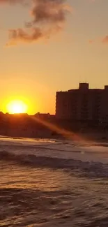 Sunset over the beach with waves and a golden sky.