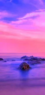 Serene violet and pink sunset beach wallpaper with ocean and rocks.