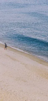 A scenic beach view with two people walking along the shore and gentle waves.