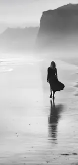 A solitary figure walks along a misty beach.