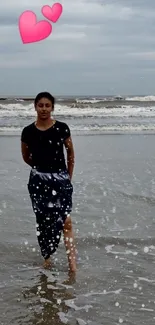 Woman walking on a serene beach with waves splashing.