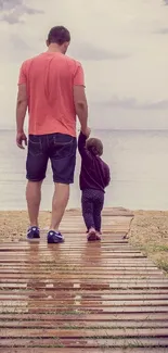 Father and child walking on a serene beach pathway.