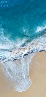 Aerial view of pristine beach waves meeting the sandy shore.