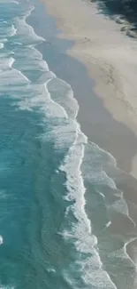 Aerial view of ocean waves meeting the sandy beach, creating a serene coastal scene.