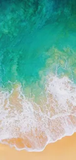 Aerial view of turquoise ocean waves meeting sandy beach shore.