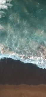 Aerial view of beach with teal waves crashing on shore.