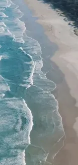 Aerial view of blue waves crashing onto a sandy beach.