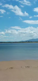 Serene beach under blue skies with clouds.