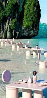 Beachfront dining tables on turquoise waters below green cliffs.