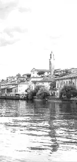 Black and white lakeside townscape with calm water reflections.