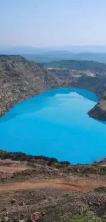 Sky-blue lake amidst rocky terrain, serene mobile wallpaper.