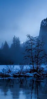 Tranquil blue landscape with forest and water under evening sky.