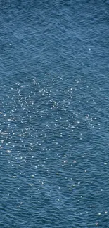 Serene waves with sunlight reflecting on the blue ocean surface.