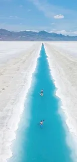 A serene blue river cutting through a vast salt flat under a clear sky.