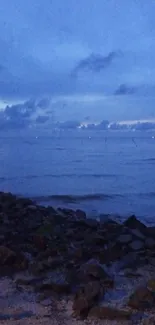 Serene twilight view over the ocean with calm waves and a blue sky.