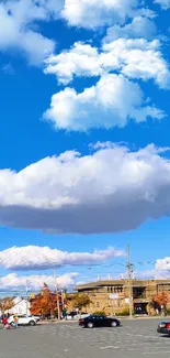 Mobile wallpaper featuring blue sky with clouds, parking lot view.