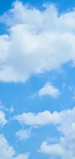 Clear blue sky with fluffy white clouds wallpaper.