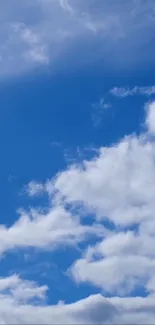 Serene blue sky with fluffy white clouds wallpaper.