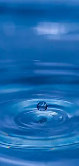 Blue water ripple with drop in focus, creating serene concentric circles.