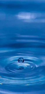 Serene blue water ripple with single drop in motion.