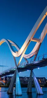 A modern bridge at dusk with water reflections and a serene blue sky.