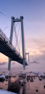 Bridge immersed in mist with a pastel sunset sky.