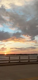 Serene sunset view over bridge with tranquil sky and clouds.