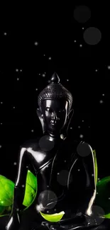 Serene black Buddha statue with green leaves on a tranquil background.