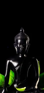 Buddha statue with green leaves on black background.