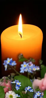 Orange candle with floral accents for mobile wallpaper.