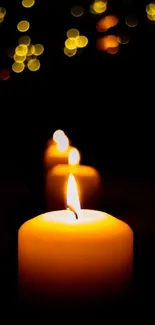 Warmly glowing candles with bokeh lights in the background.