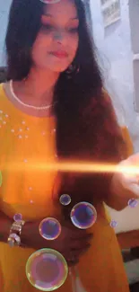 Woman in yellow dress holds glowing candle at night.