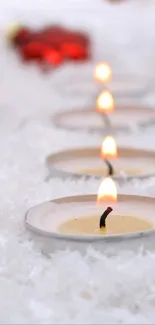 Candlelit path on snowy ground with red accents.