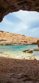 Serene view through a rocky cave opening to a tranquil beach scene.