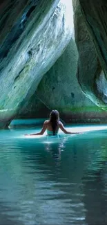 Woman in tranquil turquoise waters within a cave setting.