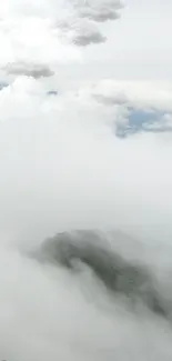 Misty mountain covered by soft, fluffy clouds.