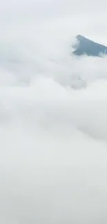 Mountain peak surrounded by misty clouds.