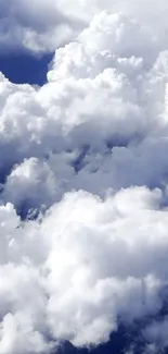 Fluffy white clouds against a deep blue sky creating a serene mobile wallpaper.