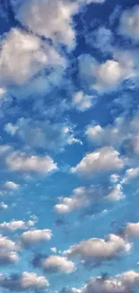 Serene blue sky with fluffy white clouds wallpaper.