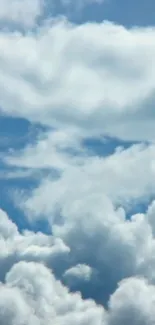 Serene blue sky with fluffy white clouds.