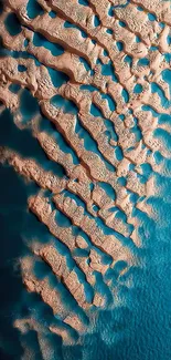 Aerial view of coastal landscape with sand and teal blue ocean.