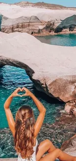 Woman enjoying serene view by turquoise waters and rocky coast.