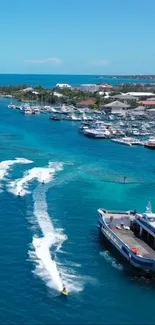 Aerial view of serene coastal harbor with boats and jet skis on cyan blue waters.